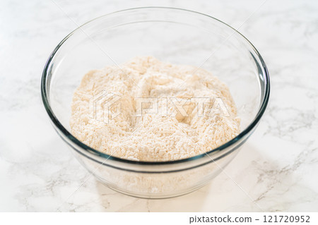 Close-up of flour in a mixing bowl, creating a smooth, sifted base for Pale Gingerbread Cookies with Subtle Spice Flavor. Ready for spices to be added. Close-up of flour in a mixing bowl, creating a smooth, sifted base for Pale Gingerbread Cookies with Subtle Spice Flavor. Ready for spices to be added. 121720952