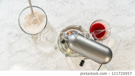 A baking setup with a stand mixer, flour with spices, softened butter, and molasses mixture, all set up to create the Classic Red Gingerbread Dough. Each ingredient is prepared and ready for mixing. A baking setup with a stand mixer, flour with spices, softened butter, and molasses mixture, all set up to create the Classic Red Gingerbread Dough. Each ingredient is prepared and ready for mixing. 121720957