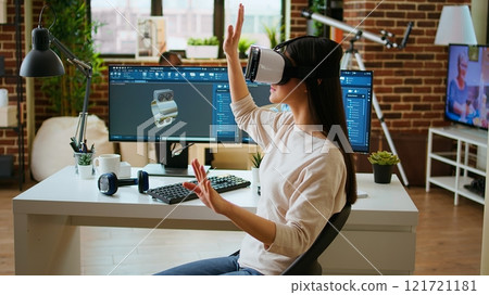 Asian woman engineer creating prototypes with vr glasses and 3D modeling software, working from home to develop new manufacturing gears and turbines. 3D design tech tools. Camera A. Asian woman engineer creating prototypes with vr glasses and 3D modeling software, working from home to develop new manufacturing gears and turbines. 3D design tech tools. Camera A. 121721181