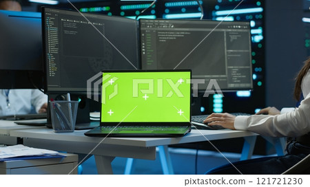 Data center engineer responsible for installation of networking equipment solving tasks on isolated screen laptop. Woman doing maintenance on server room infrastructure using mockup notebook, camera A 121721230