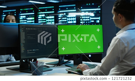 Engineer in data center monitoring security threats using mockup computer, implementing cybersecurity measures. Man using green screen PC, ensuring compliance with regulations, camera A Engineer in data center monitoring security threats using mockup computer, implementing cybersecurity measures. Man using green screen PC, ensuring compliance with regulations, camera A 121721232