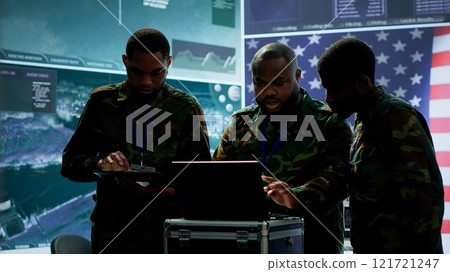 Military officer in a high tech control center engages in cybersecurity operations, protecting classified data from threats and managing digital warfare strategies to maintain state secrets. Camera A. 121721247