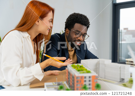 Colleagues working together on the project in the architect office 121721248