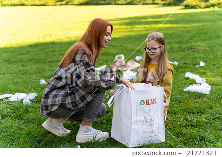Caucasian female kid and woman volunteering outdoor collecting glass garbage in park 121721321