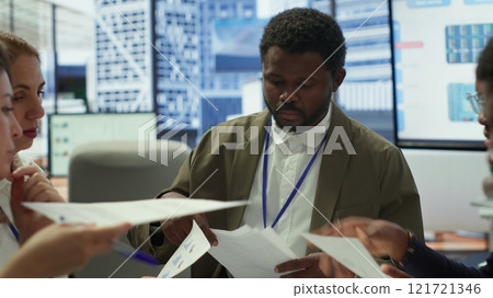 Enterprise manager works with his staff on creating a business strategy and setting goals, studying market dynamics and sales numbers. Corporation team attends a development meeting. Camera A. 121721346