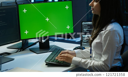 System administrator in data center installing software on green screen computer, troubleshooting issues. IT expert uses mockup PC in server hub, establishing performance benchmarks, camera A System administrator in data center installing software on green screen computer, troubleshooting issues. IT expert uses mockup PC in server hub, establishing performance benchmarks, camera A 121721358