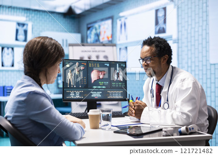 Physician explaining diagnostic report to woman patient in cabinet, discussing about health insurance and medical services. African american doctor gives professional advice and feedback to client. Physician explaining diagnostic report to woman patient in cabinet, discussing about health insurance and medical services. African american doctor gives professional advice and feedback to client. 121721482