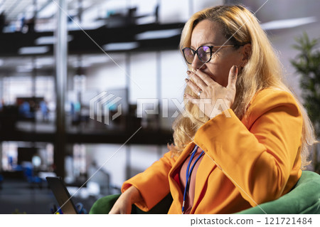Female executive feeling sick and exhausted in a meeting to discuss strategies and corporate growth. Leader in a diverse work environment having a migraine and being overworked, success story. 121721484