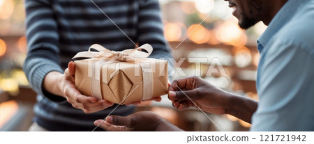 A close-up of hands giving a beautifully wrapped gift to another person. The scene conveys warmth, care, and symbolizes gratitude. A close-up of hands giving a beautifully wrapped gift to another person. The scene conveys warmth, care, and symbolizes gratitude. 121721942