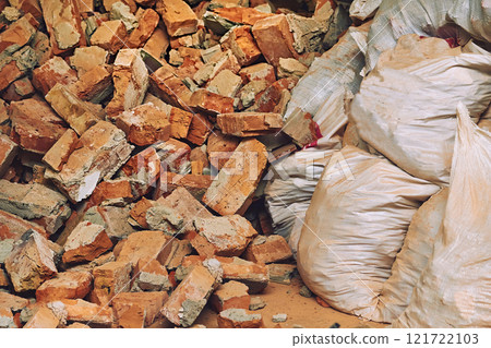 Broken trash in bags. A pile of red brick fragments. Cleaning and repair Broken trash in bags. A pile of red brick fragments. Cleaning and repair 121722103