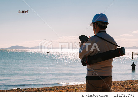 Workers surveying using a drone Workers surveying using a drone 121723775