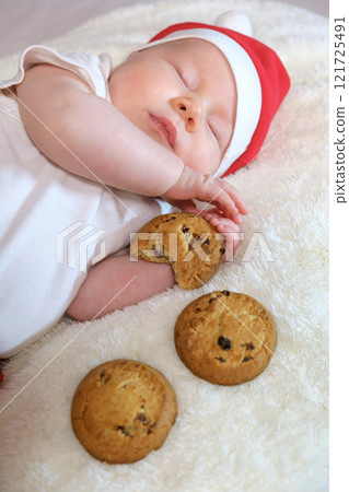 Two-Month-Old Baby in a Christmas Outfit with Milk and Cookies. Selective Focus Two-Month-Old Baby in a Christmas Outfit with Milk and Cookies. Selective Focus 121725491