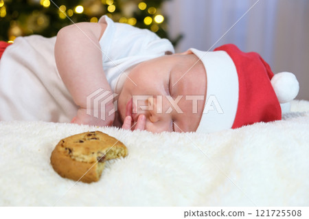 Two-Month-Old Baby in a Christmas Outfit with Milk and Cookies. Selective Focus Two-Month-Old Baby in a Christmas Outfit with Milk and Cookies. Selective Focus 121725508