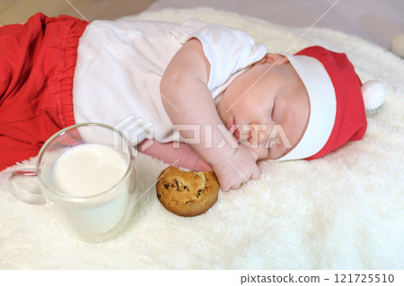 Two-Month-Old Baby in a Christmas Outfit with Milk and Cookies. Selective Focus Two-Month-Old Baby in a Christmas Outfit with Milk and Cookies. Selective Focus 121725510