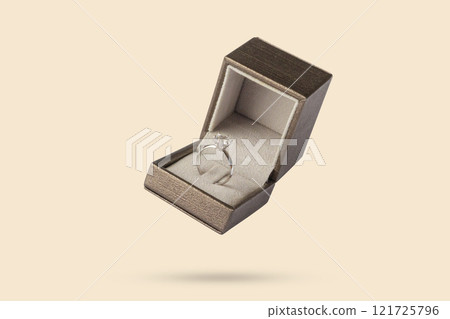 Diamond ring in jewelry gift box floated on brown background Diamond ring in jewelry gift box floated on brown background 121725796