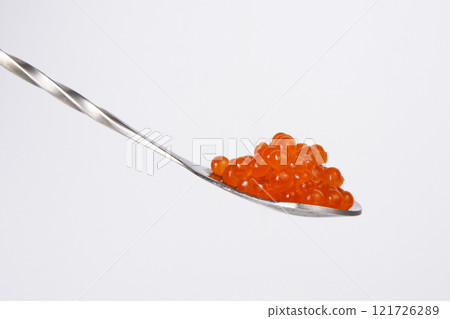 Red caviar in silver spoon isolated on the white background Red caviar in silver spoon isolated on the white background 121726289