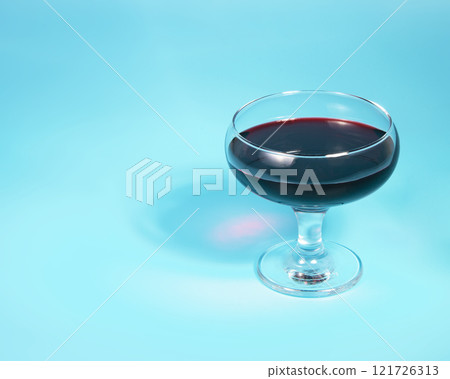 Red wine in glass on blue background with copy space Red wine in glass on blue background with copy space 121726313