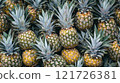 Fresh pineapples displayed together in a vibrant market setting 121726381