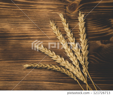 Natural wheat on wooden desk background with copyspace 121726713