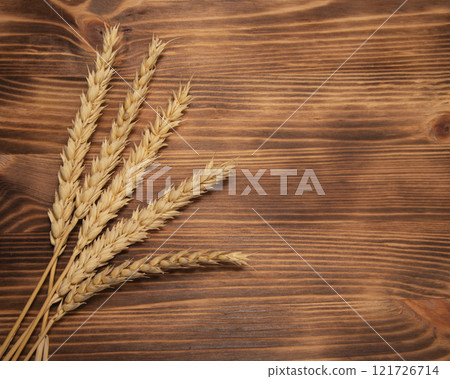 Natural wheat on wooden desk background with copyspace 121726714