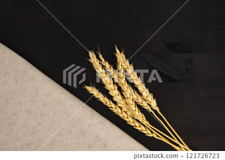 Natural wheat on craft fabric concept on dark black background with copy space Natural wheat on craft fabric concept on dark black background with copy space 121726723