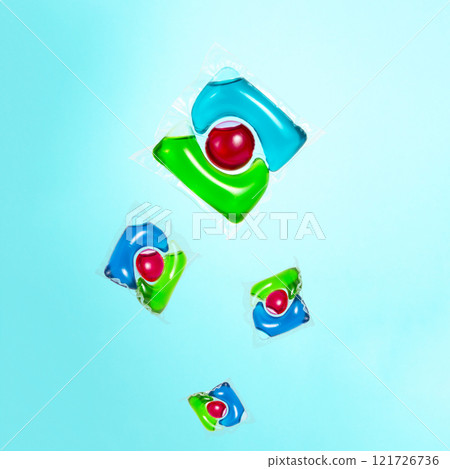 Liquid powder in gel capsule for washing multicolor on blue background 121726736