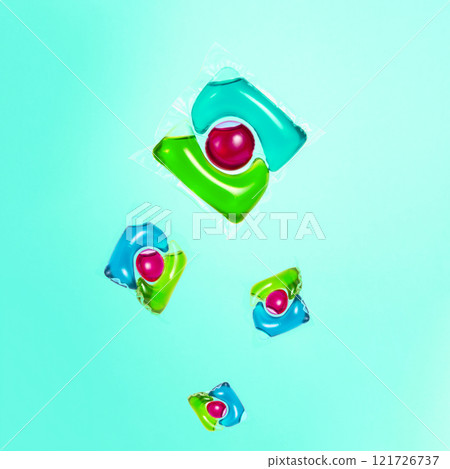 Liquid powder in gel capsule for washing multicolor on blue background 121726737