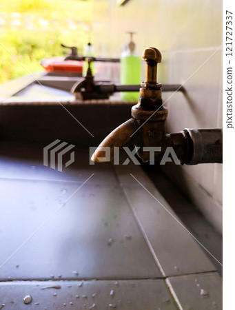 Close-Up of Brass Water Tap Over Sink Close-Up of Brass Water Tap Over Sink 121727337