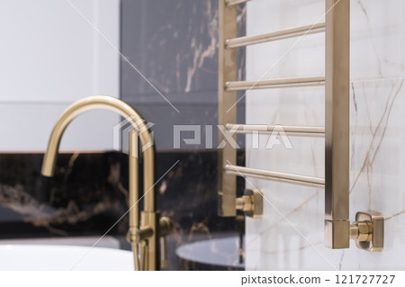 gold-colored heating radiator on a granite wall in the bathroom gold-colored heating radiator on a granite wall in the bathroom 121727727