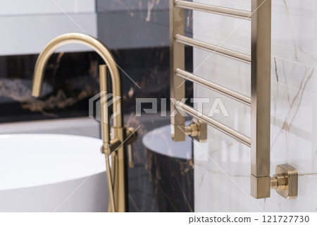 gold-colored heating radiator on a granite wall in the bathroom gold-colored heating radiator on a granite wall in the bathroom 121727730