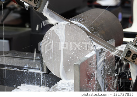The band saw cutting machine cutting the metal shaft parts with coolant method. 121727835