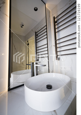 Chrome water faucet and white pedestal sink in bathroom . Stylish bathroom 121728199