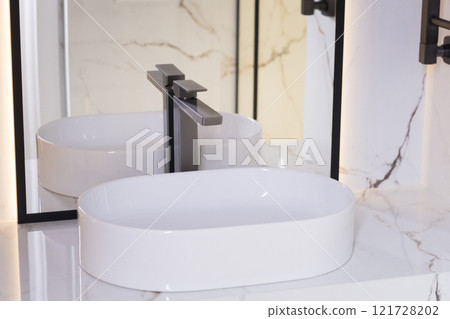 Stylish deluxe water faucet and white countertop sink in bathroom. Stylish bathroom Stylish deluxe water faucet and white countertop sink in bathroom. Stylish bathroom 121728202
