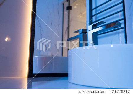 Chrome water faucet and white pedestal sink in bathroom . Stylish bathroom 121728217