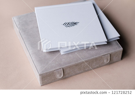 There is a photo book wrapped in a gray cloth in the box. the concept of creating fantasy books and photo albums. professional photographer and printing services There is a photo book wrapped in a gray cloth in the box. the concept of creating fantasy books and photo albums. professional photographer and printing services 121728252