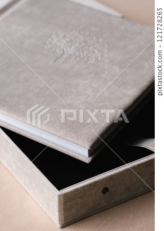 The photo book is grey in a soft cloth cover. the concept of creating books and albums from photographs. professional photographer and printing services The photo book is grey in a soft cloth cover. the concept of creating books and albums from photographs. professional photographer and printing services 121728265