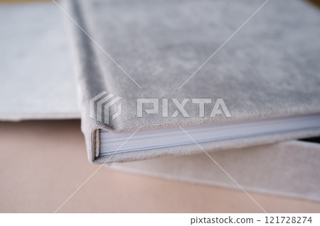 A photo book in a grey cloth cover lies on the box. the concept of creating books and albums from photographs. professional photographer and printing services 121728274