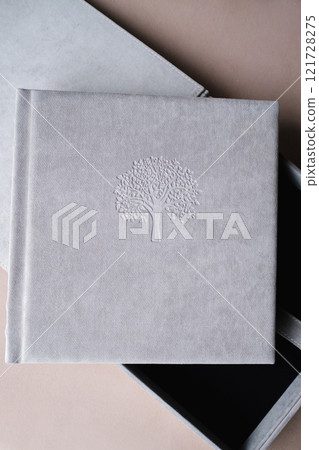 The photo book is grey in a soft cloth cover. the concept of creating books and albums from photographs. professional photographer and printing services 121728275