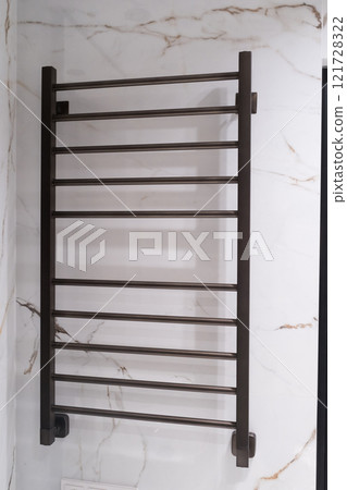 Modern black radiator on white marble wall in bathroom. New bathroom with granite white tiles 121728322