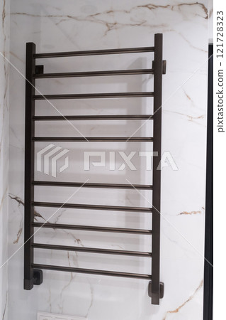Modern black radiator on white marble wall in bathroom. New bathroom with granite white tiles Modern black radiator on white marble wall in bathroom. New bathroom with granite white tiles 121728323