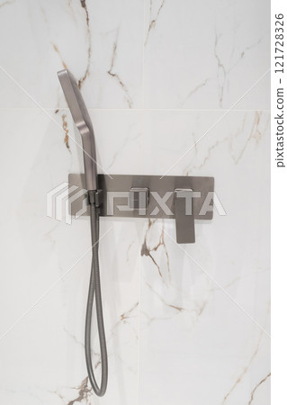 Luxury chrome faucet and shower in shower stall with white marble walls. Modern luxury shower cubicle 121728326