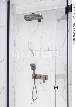 New stylish faucet and shower in shower enclosure with white granite walls. Modern luxury shower cubicle New stylish faucet and shower in shower enclosure with white granite walls. Modern luxury shower cubicle 121728334