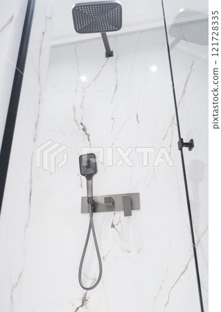 New stylish faucet and shower in shower enclosure with white granite walls. Modern luxury shower cubicle New stylish faucet and shower in shower enclosure with white granite walls. Modern luxury shower cubicle 121728335