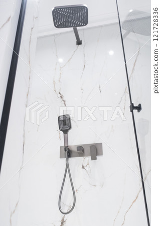 Luxury chrome faucet and shower in shower stall with white marble walls. Modern luxury shower cubicle Luxury chrome faucet and shower in shower stall with white marble walls. Modern luxury shower cubicle 121728336