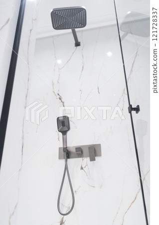 New stylish faucet and shower in shower enclosure with white granite walls. Modern luxury shower cubicle New stylish faucet and shower in shower enclosure with white granite walls. Modern luxury shower cubicle 121728337