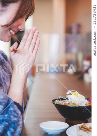 Young woman eating ramen after saying itadakimasu 121728432