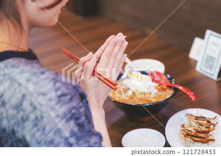 Young woman eating ramen after saying itadakimasu 121728433