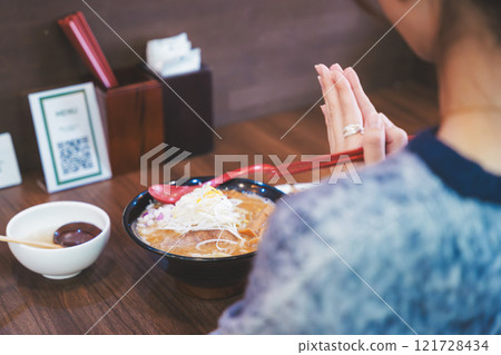 Young woman eating ramen after saying itadakimasu 121728434