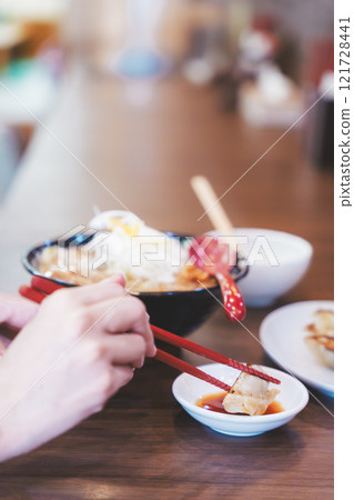 A young woman eating dumplings A young woman eating dumplings 121728441