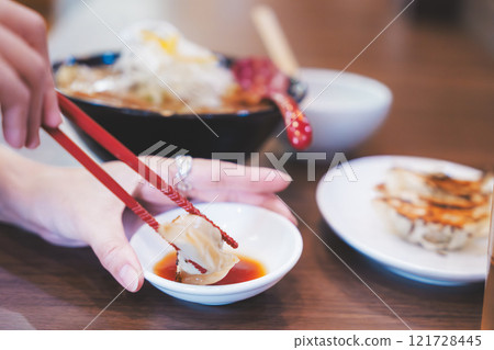 一個年輕女子吃餃子 121728445